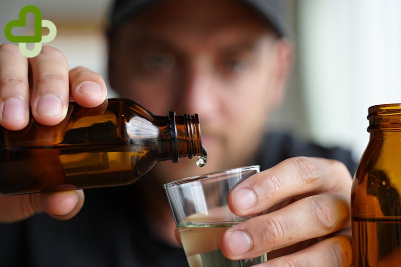 Мужчина наливает алкоголь в рюмку